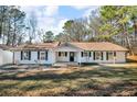 Well-maintained ranch home boasting new white siding and manicured landscaping at 2401 Phillips Rd, Lithonia, GA 30058