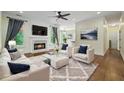 Bright living room featuring a fireplace, plush seating, and large windows showcasing the outdoor view at 2455 Ivey Oaks Rd, Cumming, GA 30041