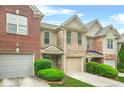 Beautiful townhome with a brick exterior, attached garage, and neatly trimmed bushes at 1622 Honeysuckle Path, Conyers, GA 30012