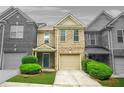 Charming townhome featuring a two-car garage, well-maintained lawn, and inviting entryway at 1622 Honeysuckle Path, Conyers, GA 30012