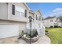 Inviting two-story home features neutral siding, black shutters, and landscaped front yard with an attached garage at 251 Hunt Club Cir, Temple, GA 30179