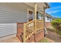 Close-up of the brick-lined front porch with newly installed wood railing and stairs, adding to the home's curb appeal at 2664 Olive Springs Se Rd, Marietta, GA 30060