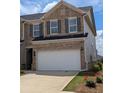 Charming brick townhouse showcasing a two-car garage and manicured landscaping at 867 Pensive Run, Dacula, GA 30019
