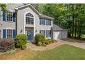 A charming home with blue shutters, a blue door, and an attached two-car garage at 3927 Collier Nw Trce, Kennesaw, GA 30144