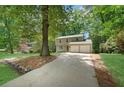 View of the home with a long driveway flanked by mature trees in a serene setting at 4368 Heritage Glen Ct, Marietta, GA 30068