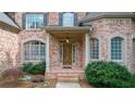 Inviting front entrance with brick detail, a covered porch, and decorative landscaping at 5041 Corinault Nw Pl, Acworth, GA 30101