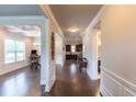 Spacious hallway with hardwood floors and decorative trim leads to the dining, kitchen and bathroom areas at 6390 Yellow Birch St, Cumming, GA 30040