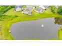An aerial view of neighborhood houses and green space surrounding a large pond with a water feature at 6390 Yellow Birch St, Cumming, GA 30040