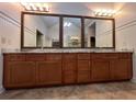 Spacious bathroom vanity with marble countertop, wooden cabinets, and three framed mirrors at 2785 Old Sewell Rd, Marietta, GA 30068
