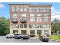 Exterior shot of a brick condo building with arched windows and parking at 319 Atlanta Se St # 315, Marietta, GA 30060