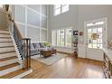 Bright foyer showcasing hardwood floors, staircase, and a large window with stylish window shutters at 3750 Sweeting St, Cumming, GA 30041