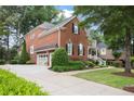 Side view of a well-maintained brick home with a long driveway and attached garage at 2630 Weddington Ne Pl, Marietta, GA 30068