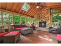 Cozy sunroom with a wood-burning fireplace, skylight, wood ceiling and flooring, and comfortable seating at 4507 Reva Way, Marietta, GA 30066