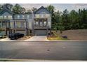 Charming two-story townhome with a stone-accented base, private porch, and driveway at 507 Bishop Ln, Woodstock, GA 30188