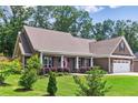 Well-maintained home with lush landscaping, a cozy front porch, and a two-car garage, offering a warm and welcoming atmosphere at 59 Grand Georgian Ne Ct, Cartersville, GA 30121
