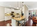Modern kitchen featuring granite countertops, an island with seating, and stainless steel appliances at 59 Grand Georgian Ne Ct, Cartersville, GA 30121