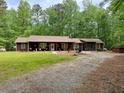 Cozy home with a gravel driveway surrounded by lush greenery, offering a serene setting at 712 Honeysuckle Ln, Temple, GA 30179