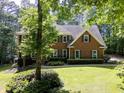 Traditional brick home with shutters, mature trees, landscaped yard, and a well-maintained lawn at 4673 Jefferson Township Pl, Marietta, GA 30066
