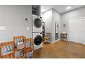 Bright laundry room with stacked washer and dryer, wooden shelving, and stylish decor elements at 5300 Peachtree Rd # 105, Atlanta, GA 30341