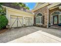 View of the attached garage and entrance with stone and siding at 931 Windsor Creek Dr, Grayson, GA 30017