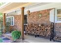 Close up of the front porch with brick columns and rustic wood stacked near the front door at 255 Shipp Cir, Hiram, GA 30141