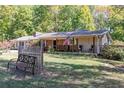 View of well-maintained lawn, bench and charming covered front porch with rocking chairs at 255 Shipp Cir, Hiram, GA 30141