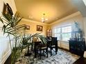 Bright dining room with a large window, decorative cabinet, and stylish table perfect for Gathering meals at 2579 Wimberley Pine Ct, Dacula, GA 30019