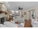 Bright living room with wood floors, fireplace, ceiling fan, and white bookshelves for storage at 11190 Hembree Springs Dr, Roswell, GA 30076