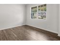 Bright bedroom features hardwood floors and a large window offering neighborhood views at 3941 Fairhaven Rd, Lithia Springs, GA 30122
