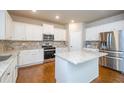 Modern kitchen with white cabinets, stainless steel appliances, granite countertops and hardwood floors at 3405 Linstead Ct, Loganville, GA 30052