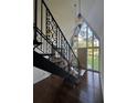 Inviting foyer with hardwood floors, decorative lighting and a custom wrought iron staircase at 4274 Smithsonia Ct, Tucker, GA 30084
