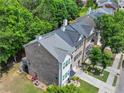 Aerial shot of the rear exterior of the townhome with a deck and patio, showcasing the well-maintained landscaping at 2138 Mill Garden Run, Buford, GA 30519