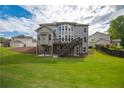 Large backyard view featuring a deck, a neutral paint color, and lush green grass at 3825 Valleyway Rd, Cumming, GA 30040