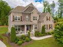 Beautiful two-story brick home with a manicured lawn, complimented by professional landscaping and a charming front porch at 3825 Valleyway Rd, Cumming, GA 30040