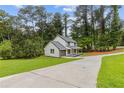 This two-story home features a long driveway and manicured lawns, set amongst mature shade trees at 4657 Lou Ivy Rd, Peachtree Corners, GA 30096