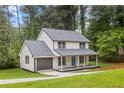 Inviting two-story home boasts a fresh exterior, complemented by a well-manicured lawn and lush trees at 4657 Lou Ivy Rd, Peachtree Corners, GA 30096