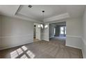 Inviting dining room with plush carpet, tray ceiling, and an elegant chandelier at 4954 Penscot Way, Stone Mountain, GA 30088