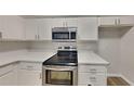 Modern kitchen featuring white cabinets, stainless steel appliances, and quartz countertops at 700 Patriots Point St, Locust Grove, GA 30248