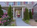 Inviting front porch with stone accents, lush landscaping, and a glass paneled front door at 126 Oakleigh Pointe Dr, Dallas, GA 30157