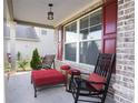 Cozy front porch with rocking chairs, an ottoman, and red accents at 126 Oakleigh Pointe Dr, Dallas, GA 30157