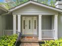 Inviting covered entryway with white columns and decorative glass front door at 1260 Willeo Creek Dr, Roswell, GA 30075
