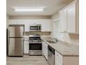 Bright kitchen features stainless steel appliances, white cabinets, granite countertops, and a window at 3084 Fern Valley Sw Dr, Marietta, GA 30008