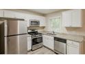 Modern kitchen features stainless steel appliances, white cabinets, granite countertops, and a bright window at 3084 Fern Valley Sw Dr, Marietta, GA 30008