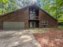 Home with garage and second story balcony in wooded setting at 3835 Shawnee Sw Run, Lilburn, GA 30047
