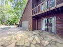 Side view of the home featuring a stone patio and spacious driveway at 3835 Shawnee Sw Run, Lilburn, GA 30047