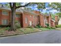 Beautiful red brick townhome with manicured landscaping and a charming front entrance with mature trees at 40 Ivy Chase Ne, Atlanta, GA 30342