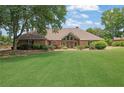 Charming brick home with a beautifully landscaped front yard and mature trees for added curb appeal at 5950 Meadow Brook Ln, Cumming, GA 30040