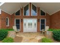 Inviting front porch with stone accents, chairs and a brick exterior providing curb appeal at 5950 Meadow Brook Ln, Cumming, GA 30040