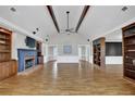 Open living room featuring hardwood floors, exposed beams and a cozy fireplace at 5950 Meadow Brook Ln, Cumming, GA 30040
