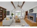 Bright living room boasts vaulted ceilings, exposed beams, hardwood floors and a cozy fireplace at 5950 Meadow Brook Ln, Cumming, GA 30040